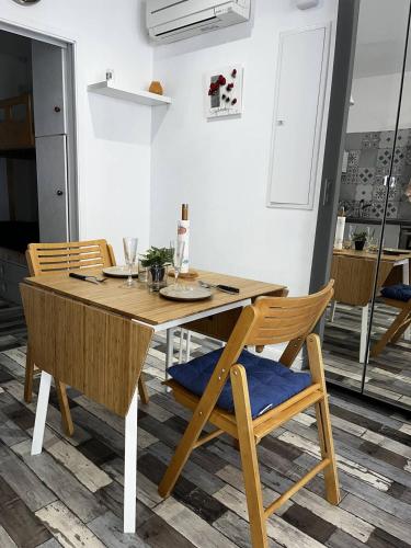 - une table et des chaises en bois dans la cuisine dans l'établissement T2 confortable avec climatisation à 100 m de la plage - 4HOUS34, à Canet