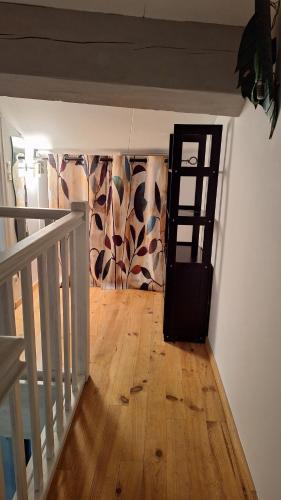 a hallway with a stairway with a wooden floor and a door at Vacance et Cure dans Duplex 80 M2 à CERET 66400 in Céret