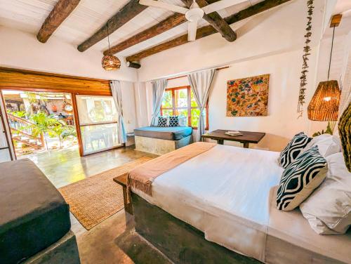 a bedroom with a large bed in a room with windows at Casa Coraje in Palomino