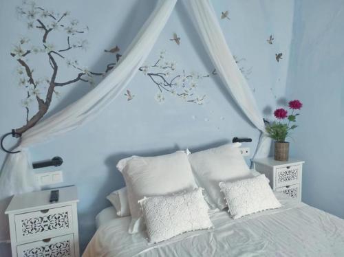 a bedroom with blue walls and a bed with white pillows at La Media Luna in Segorbe