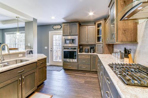 a kitchen with wooden cabinets and stainless steel appliances at Mountain Views and Brook Access Home in Arkville! in Arkville