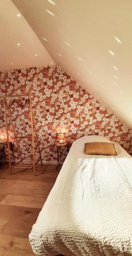 - une chambre avec un lit et un mur de fleurs dans l'établissement Le Bon Temps, pour de jolis moments, à Saint-Martin-lez-Tatinghem