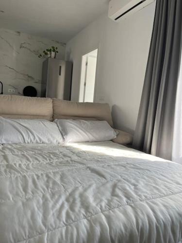 a white bed in a room with a window at Casa La Fuente Alta in Algodonales
