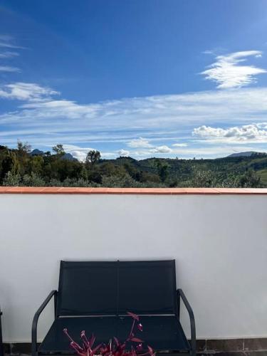 a black bench sitting on top of a white wall at Casa La Fuente Alta in Algodonales