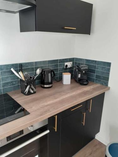 - une cuisine avec un comptoir en bois et du carrelage vert dans l'établissement Appartement 2 personnes - fibre, à Dijon