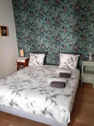 une chambre avec un lit avec un papier peint fleuri dans l'établissement Appartement 2 personnes - fibre, à Dijon