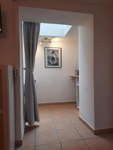 Camera con porta, tenda e pavimento piastrellato. di Gemütliches Studio-Apartment für 2 Personen in Toplage a Colonia