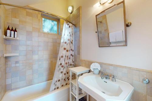 a bathroom with a sink and a tub and a mirror at Cottage Charms in South Lake Tahoe