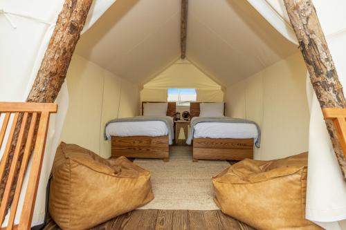 two beds in a small room in a tent at Under Canvas Great Smoky Mountains in Pigeon Forge