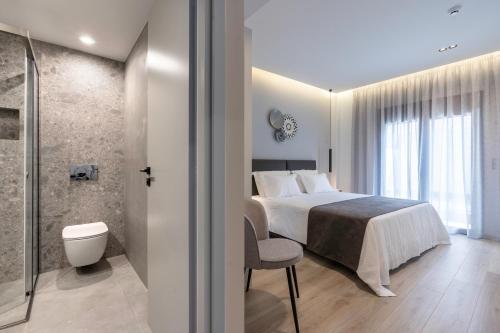 a bedroom with a bed and a bathroom with a shower at EN Suites Stylish & Comfort Stay near Acropolis in Athens