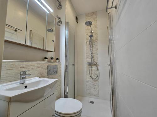 a bathroom with a toilet and a sink and a shower at Central City White Line in Kiel