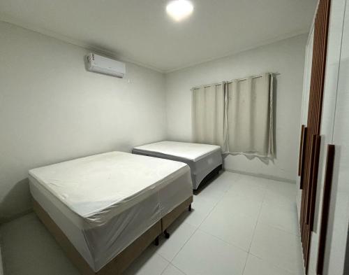 een kamer met twee bedden en een raam bij Casa de Praia Temporada in Prado