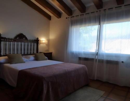 una camera da letto con un letto e una grande finestra di Casa Rural Fuentebuena a Matabuena