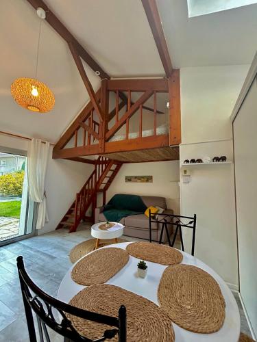 une chambre avec une table, des chaises et une mezzanine dans l'établissement Maisonnette 2 à 4 pers- Jardin privatif clôturé- Calme- Stationnement Gratuit- Pau Ouest Billère, à Billère