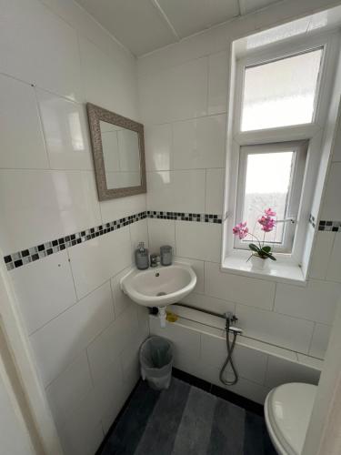 a white bathroom with a sink and a window at Spacious rooms for rent 10 min from Tower Bridge in London