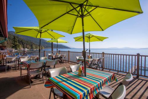 a deck with tables and chairs with umbrellas at The Islander Inn in Bigfork