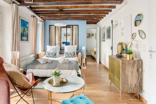 une chambre avec un lit et une table dans une pièce dans l'établissement Marais2 Place des Vosges peaceful air-conditioned, à Paris