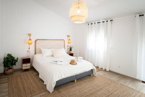 una camera da letto con un grande letto bianco con due cappelli di Lo Mas de Paiall a Deltebre