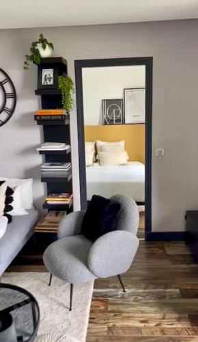 - un salon avec une chaise et un lit dans l'établissement Charmant appartement avec vue lac et montagnes, à Sévrier