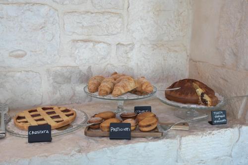 a table with several different types of bread and pastries at Masseria Surace in Noci