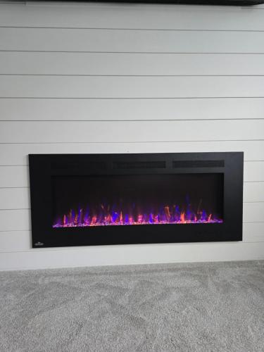 a fireplace against a white wall with a fire place at Private 1 bedroom in Brookswood in Langley