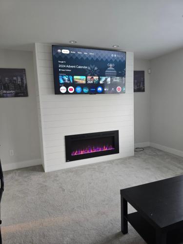 a living room with a fireplace with a tv on the wall at Private 1 bedroom in Brookswood in Langley