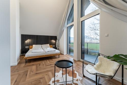 a bedroom with a bed and a large window at Dom Czarna Owca - Widok na góry, sauna - SpaceApart in Karpacz