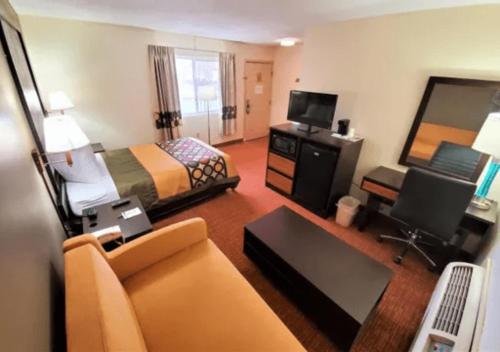 a hotel room with a bed and a couch at The Sullivan Inn in Monticello