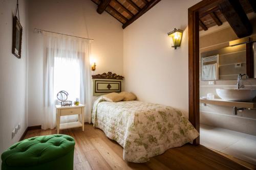 a bedroom with a bed and a bathroom with a sink at Agriturismo Le Volpi in Baone