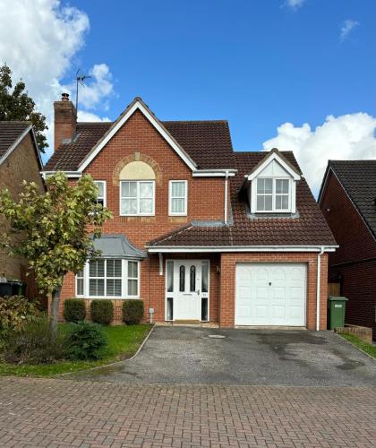 a brick house with white garage doors at Spacious four bed detached home in Nottingham in Nottingham