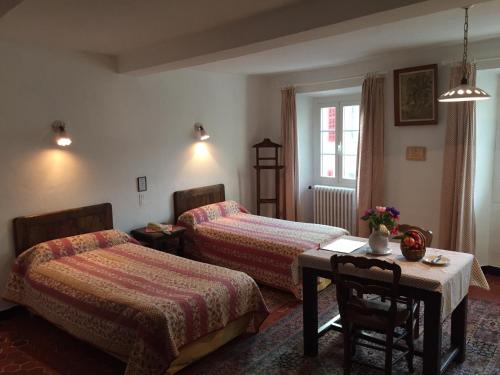 a hotel room with two beds and a table and a table sidx sidx at Auberge des Seigneurs in Vence