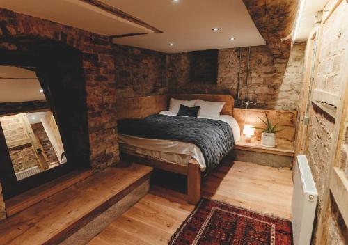 a bedroom with a bed and a brick wall at Lyde Court Country House in Hereford