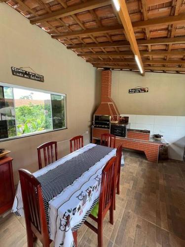 Una cocina con una mesa con sillas y una estufa. en Chácara Almeida, en Socorro