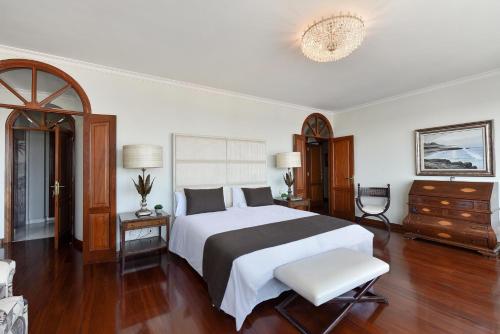 a bedroom with a large white bed and wooden floors at Seaview Holiday Rental by VillaGranCanaria in Las Palmas de Gran Canaria