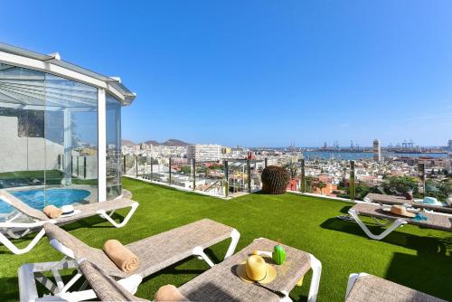 a rooftop patio with lawn chairs and a pool at Seaview Holiday Rental by VillaGranCanaria in Las Palmas de Gran Canaria