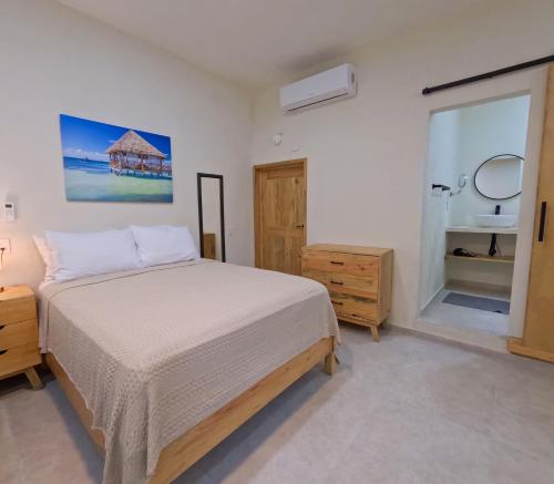 a bedroom with a bed and a bathroom with a mirror at The Mermaid and The Pearl Boutique Hotel in Isla Mujeres