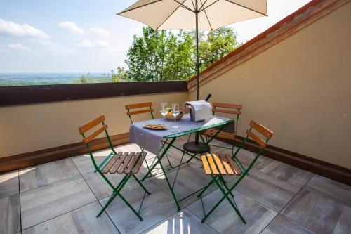 a table and chairs on a balcony with an umbrella at Agriturismo Le Volpi in Baone