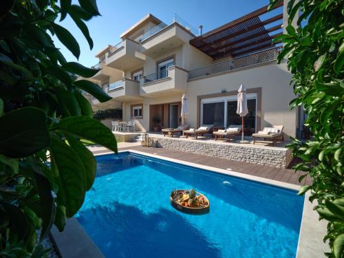 a villa with a swimming pool and a house at Chrissiida Villa in Ialyssos