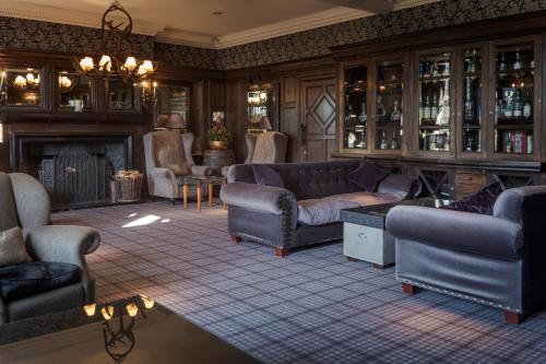 a living room with couches and a fireplace at Slaley Hall Hotel, Spa & Golf Resort in Slaley