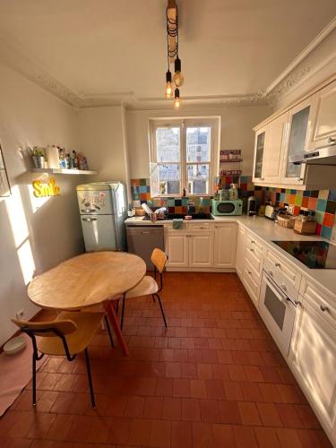 une cuisine avec une table et une petite table. dans l'établissement Le Refuge Bohème, à Paris