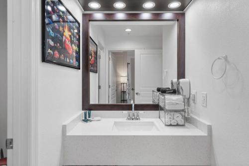 Un baño con lavabo y un espejo grande. en 3 Beds Disneyfree Shuttle, en Orlando