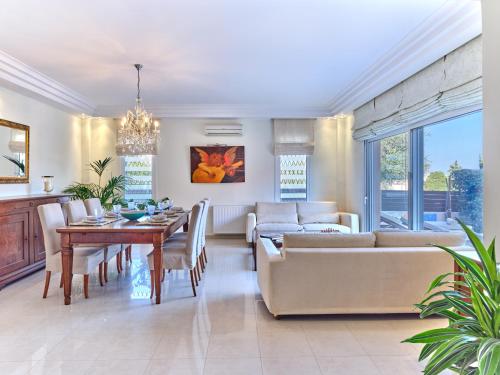 a dining room and living room with a table and couch at Chrissiida Villa in Ialyssos