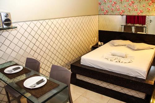 a hotel room with a bed and a table with chairs at Hotel & Motel Henrique Dias (Adults Only) in Recife