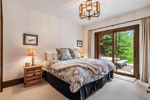 a bedroom with a bed and a sliding glass door at Private Ski-out Village Home in Vail with Hot Tub in Vail