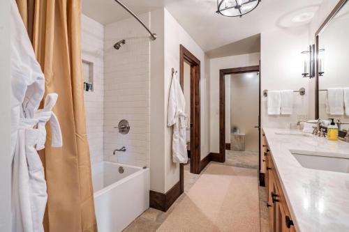 a white bathroom with a tub and a sink at Private Ski-out Village Home in Vail with Hot Tub in Vail