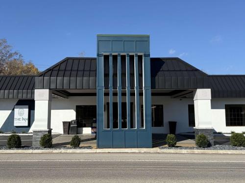a white and black building with a blue door at The Inn At Tree City, BW Signature Collection in McMinnville