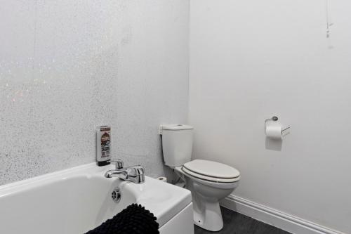 a white bathroom with a toilet and a bath tub at Mariah Flat - 2 Bedroom getaway in Pontypool in Pontypool