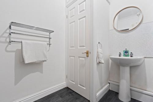 a white bathroom with a sink and a mirror at Mariah Flat - 2 Bedroom getaway in Pontypool in Pontypool