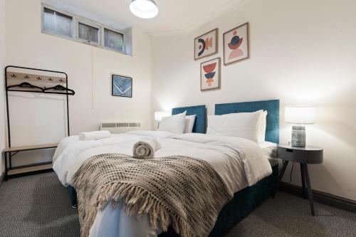 a bedroom with a large bed with a blue headboard at Mariah Flat - 2 Bedroom getaway in Pontypool in Pontypool