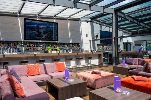 a room with couches and a bar with a tv at Park Inn by Radisson Berlin Alexanderplatz in Berlin